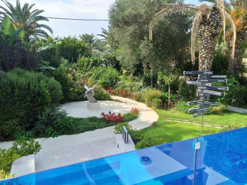 a garden with a statue and a swimming pool at TRYP by Wyndham Corfu Dassia in Dassia