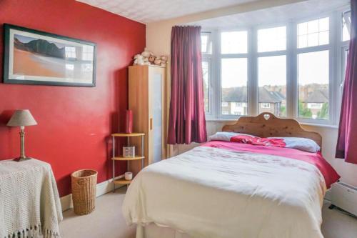 1 dormitorio con 1 cama con paredes y ventanas de color rojo en Impeccable 3-Bed House in Nottingham Central en Nottingham