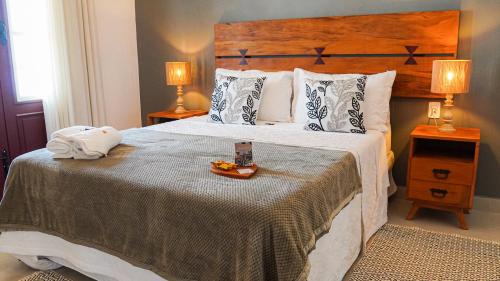 a bedroom with a bed with a tray of food on it at Pouso da Rita - Tiradentes in Tiradentes