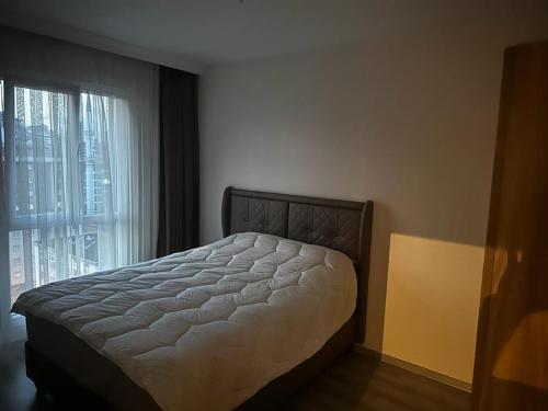 - une chambre avec un lit et une grande fenêtre dans l'établissement Kiralık Daire, à Istanbul