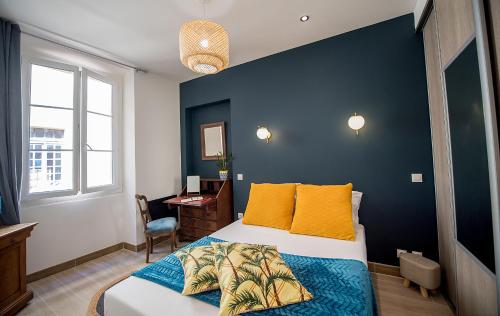 een slaapkamer met een bed met een blauwe muur bij Magnifique 2 pièces lumineux Vieux Nice in Nice