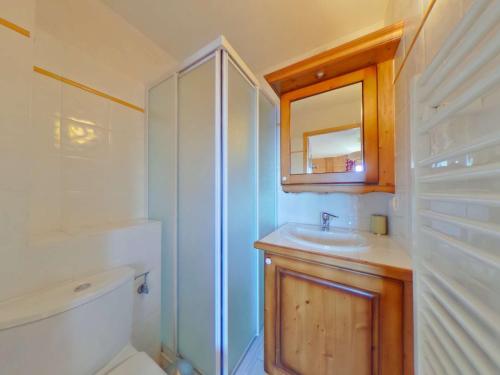 a bathroom with a sink and a toilet and a mirror at Appartement Villard-sur-Doron, 3 pièces, 8 personnes - FR-1-594-40 in Villard-sur-Doron