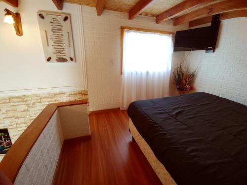 1 dormitorio con cama y ventana en Don Galle en El Chaltén
