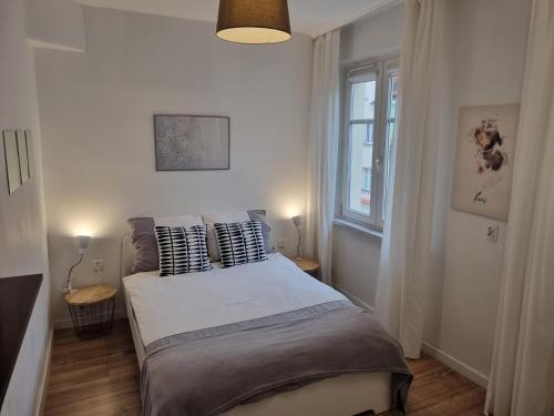 1 dormitorio con cama con almohadas y ventana en Apartament in Centre 2 en Bolesławiec