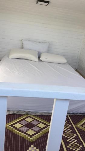 a white bed with two pillows on top of it at Tiny Otel Datca in Datca