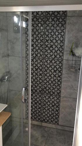 a shower with a glass door in a bathroom at Tiny Otel Datca in Datca