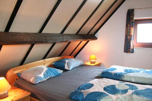 1 dormitorio con 2 camas y almohadas azules y blancas en Zeewind II 278, en Bredene