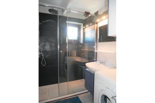 a bathroom with a shower and a sink and a washing machine at Zeewind II 278 in Bredene