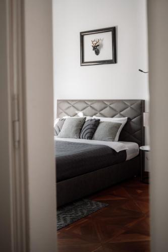 a bedroom with a bed with a silver headboard at Main Square Apartments & Rooms in Maribor
