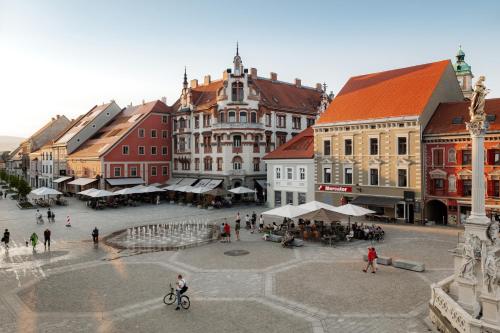 a group of people walking around a city with buildings at LA apartments in Maribor