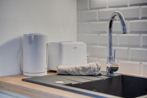 a kitchen counter with a sink with a coffee maker at L'Espadon - Appart'Escale in Saint-Nazaire