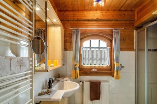 a bathroom with a sink and a window at Das Alpenhaus an der Ems in Walchum