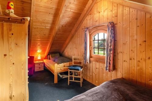 a room with a bed and a window in a cabin at Das Alpenhaus an der Ems in Walchum