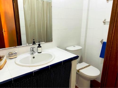 bagno con lavandino, servizi igienici e specchio di SwordFish Casa da Luz a Peniche