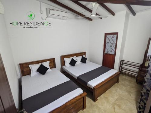 una camera con due letti e un soffitto di Hope residence a Anuradhapura