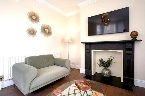 a living room with a couch and a fireplace at Stunning ground floor apartment near Southwold in Southwold