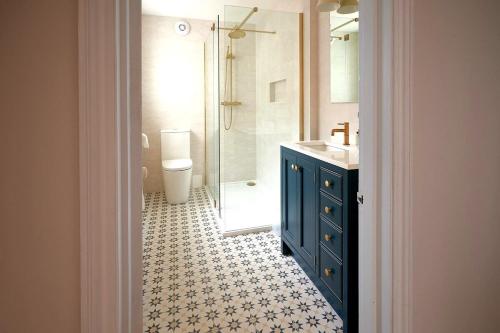 y baño con lavabo azul y ducha. en Hurn Crag House, Stunning ground floor apartment near Southwold, en Southwold