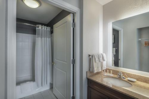 uma casa de banho com um lavatório, um chuveiro e um espelho. em Residence Inn by Marriott Washington, DC National Mall em Washington