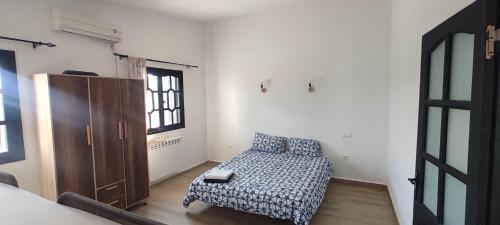 a small bedroom with a bed and a window at F2 duplex plages et promenades in Annaba