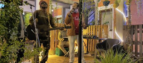 a man standing in a room with a guitar at Wow Farm House in Auroville