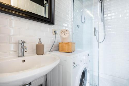 a white bathroom with a sink and a washing machine at Tirso 9 in Milan