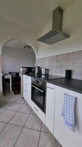 a kitchen with white cabinets and a stove top oven at Traumhaftes Studio in Top Lage! in Saint-Louis