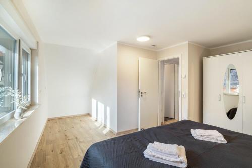 Unique Apartments Wiesloch في فيسلوخ: غرفة نوم عليها سرير وفوط