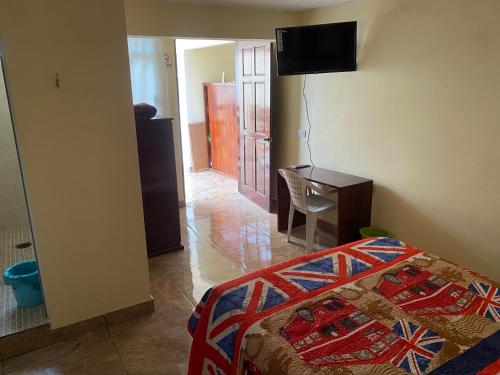 Schlafzimmer mit einem Bett, einem Schreibtisch und einem TV in der Unterkunft Hotel Colibrí Apizaco Centro in Apizaco