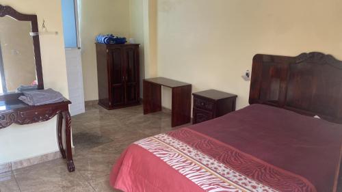 1 dormitorio con cama, tocador y espejo en Hotel Colibrí Apizaco Centro, en Apizaco