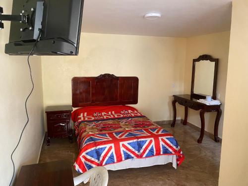 1 dormitorio con cama, espejo y TV en Hotel Colibrí Apizaco Centro, en Apizaco