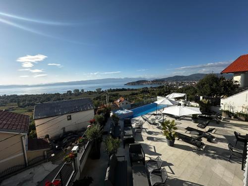 a view of a patio with a pool and tables and chairs at La Vista Luxury Villa in Ohrid