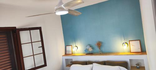 ein Schlafzimmer mit einem Deckenventilator und einer blauen Wand in der Unterkunft Parque Golf 6 in Maspalomas