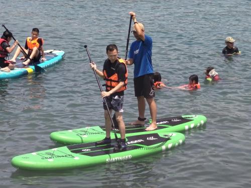 a group of people on paddle boards in the water at B&G Crafs Art House in Chenggong