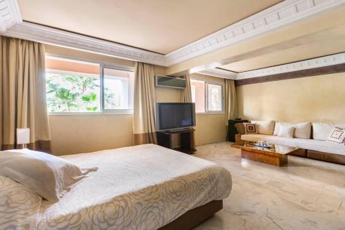 ein Schlafzimmer mit einem großen Bett und einem Sofa in der Unterkunft Somptueux Duplex au coeur de l'Hivernage in Marrakesch
