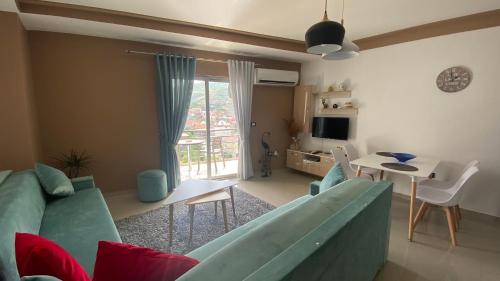 a living room with a couch and a table with chairs at Guest's Apartament in Pogradec