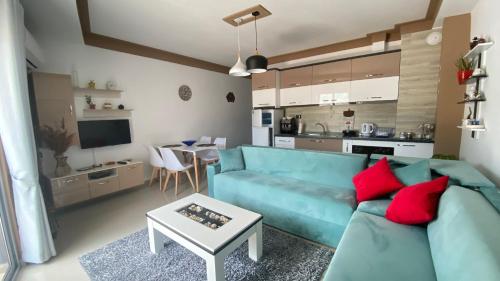 a living room with a blue couch and a kitchen at Guest's Apartament in Pogradec