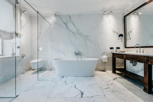 a bathroom with a tub and a shower and a sink at Hotel PURS in Andernach