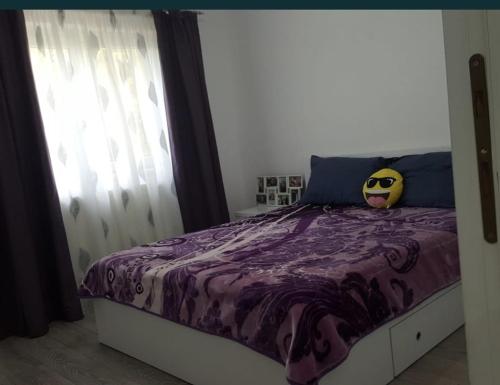 ein Schlafzimmer mit einem Bett mit einer lila Bettdecke in der Unterkunft LME Residence in Târgovişte