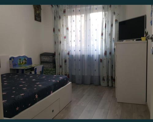 Schlafzimmer mit einem Bett und einem Flachbild-TV in der Unterkunft LME Residence in Târgovişte