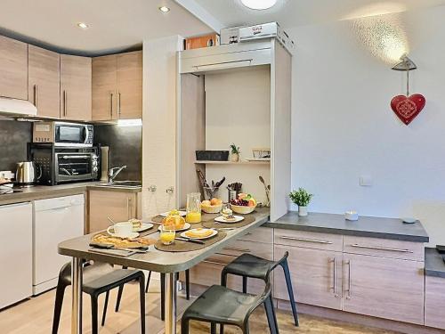 une cuisine avec une table avec de la nourriture dessus dans l'établissement Studio cabine rénové, 4 pers, proche centre et pistes, parking, wifi - FR-1-411-690, à Val dʼIsère
