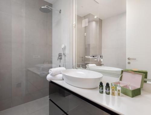 a white bathroom with a sink and a mirror at Luxury apartment Enjoyer - PRIVATE POOL with a large garden and private garage in Split