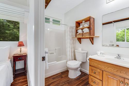 a bathroom with a toilet and a sink and a tub at Hale Olena Ohana | 31+ day rental in Keaau