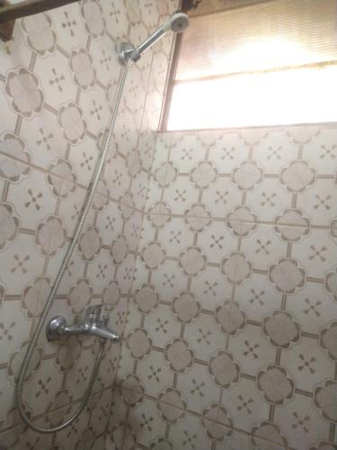 um chuveiro na casa de banho com uma cabeça de chuveiro em Tiny home hexagonal de barro y techo vivo em Santa Ana