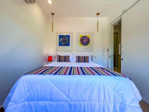 um quarto com uma cama grande e lençóis azuis em Charmoso chale c WiFi e linda vista em Itaipava RJ em Petrópolis