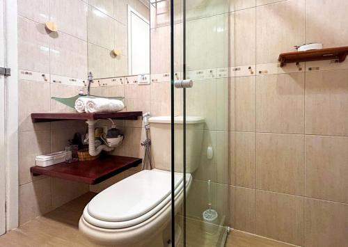 uma casa de banho com um WC e uma cabina de duche em vidro. em Charmoso chale c WiFi e linda vista em Itaipava RJ em Petrópolis