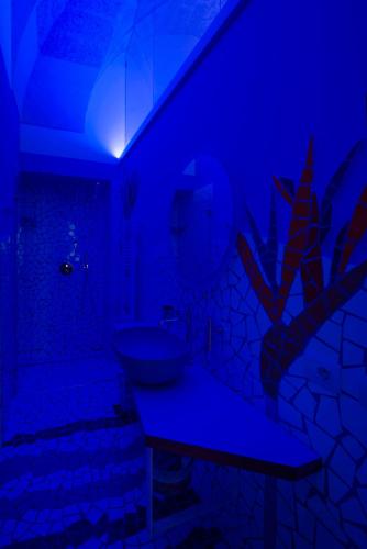 a bathroom with a sink and a blue light at VIANNA SUITES SPA in Lecce