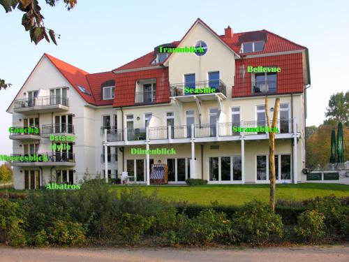 un gran edificio blanco con palabras verdes en él en Ostsee Residenz Meeresblick Meeresblick, en Poel