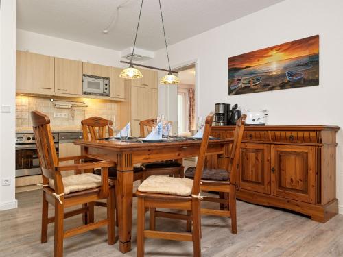 una cucina con tavolo e sedie in legno di Ostsee Residenz Meeresblick Albatros a Insel Poel