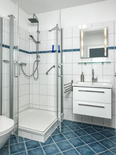 La salle de bains est pourvue d'une douche, d'un lavabo et de toilettes. dans l'établissement Landhaus Residenz Kirchsee Ostseetraum, à Poel