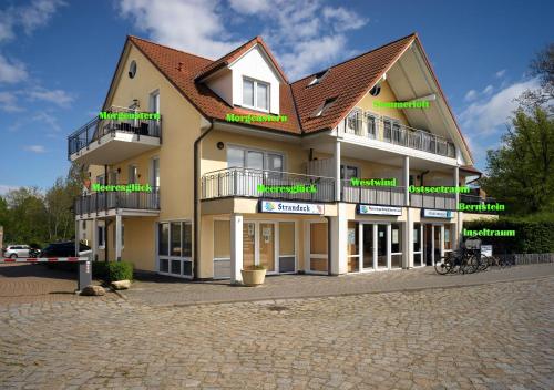 un gran edificio con letreros verdes en el lateral en Landhaus Residenz Kirchsee Ostseetraum, en Poel